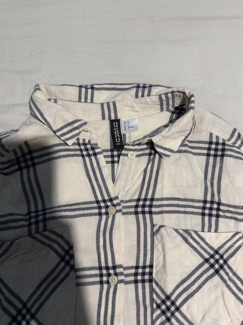 H&M Divided Plaid Long Sleeves (Category: Longsleeves) located in Santa Rosa. Submitted by micstuff (Listing ID 1456011152, Image 2). Description: - Cream long sleeve shirt - Navy blue plaid pattern - Button-up front - Two chest pockets - Collared neckline - Relaxed fit - Ideal for casual wear - Pairs well with jeans or shorts.
