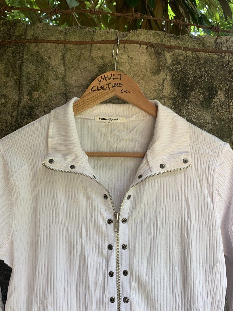 Japan Semantic Design White Ribbed Zip-Up Long Sleeve (Category: Longsleeves) located in Roxas City. Submitted by vaultcultureco. (Listing ID 1455920308, Image 3). Description: - White long sleeve top - Brand: Semantic Design - Features a ribbed texture all over - Zip-up front with snap button details - Collar can be worn up or down - Size: Medium (M) - Perfect for layering or wearing solo.