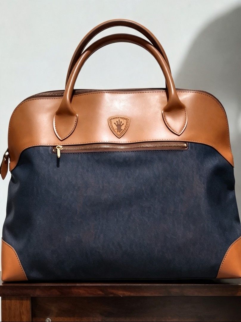 Leather Pola Handbag (Category: Luxury Bags & Wallets) located in Tarlac. Submitted by faithfulfinds (Listing ID 1455968856, Image 1). Description: Authentic POLA Japan Handbag/Weekender Condition: LIKENEW Brand: POLA Japan (Official VIP Promotional Gift) Design: Classic Navy Blue and Tan Leather Accent Size: Malaki, kasya ang pang-weekend na gamit Issue: Minimal discoloration sa bottom part at slight sa handle. YKK Zip Perfect gamitin para sa st
