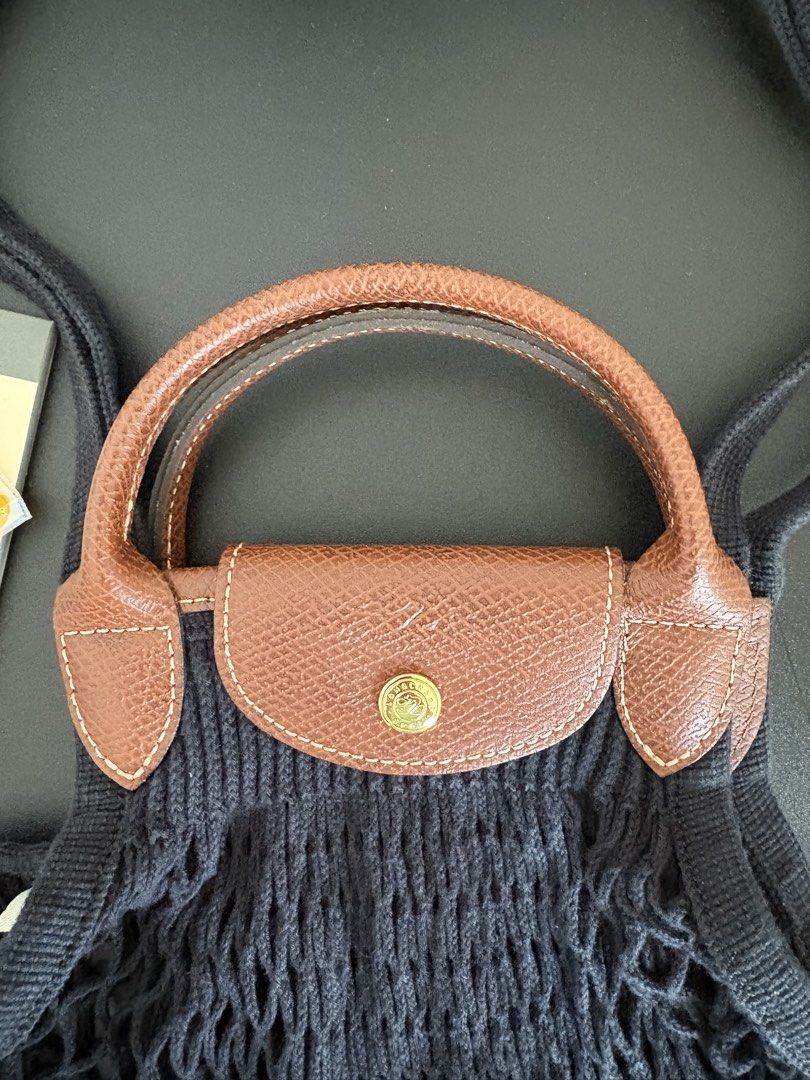 Longchamp Le Pliage Filet Bag in Large (Category: Luxury Bags & Wallets) located in Paranaque City. Submitted by chicrepeats (Listing ID 1455901061, Image 2). Description: - Black net bag - Brown leather handles and trim - Snap closure with Longchamp logo - Ideal for shopping or everyday use - Stylish and practical .