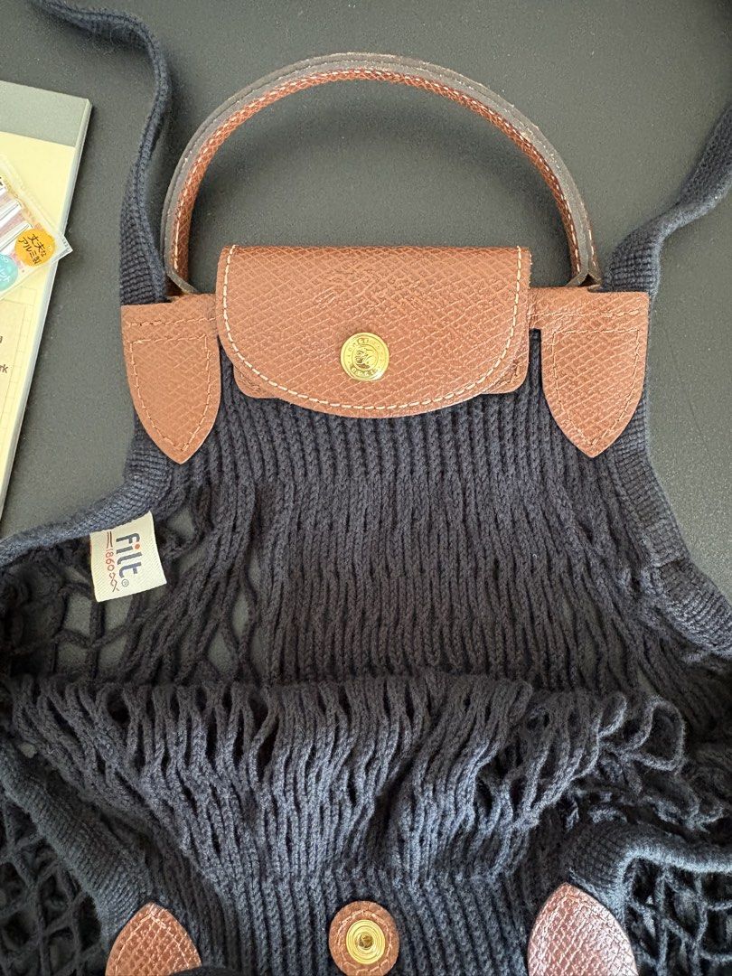 Longchamp Le Pliage Filet Bag in Large (Category: Luxury Bags & Wallets) located in Paranaque City. Submitted by chicrepeats (Listing ID 1455901061, Image 3). Description: - Black net bag - Brown leather handles and trim - Snap closure with Longchamp logo - Ideal for shopping or everyday use - Stylish and practical .
