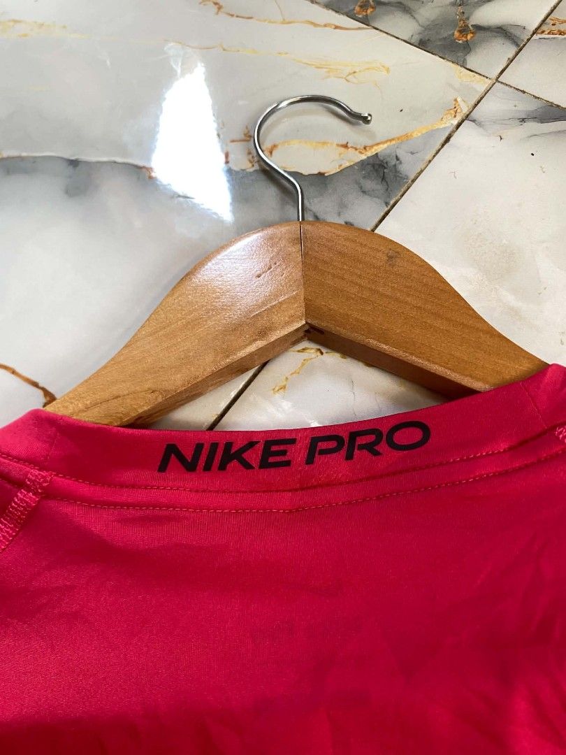 Nike Pro Dri-Fit Long Sleeve Training Shirt (Category: Activewear) located in Trinidad. Submitted by thrifter1997 (Listing ID 1455868462, Image 3). Description: -Dimes(20x28) Strechy pa -Colorate & Condition (10/10) -No Issues - Bright pink Nike Pro Dri-Fit long sleeve shirt - Size: L - Fit: Tight - Material: Polyester and Spandex blend for comfort and flexibility - Features: Nike Swoosh logo on chest, Nike Pro branding on back collar - Origin: M