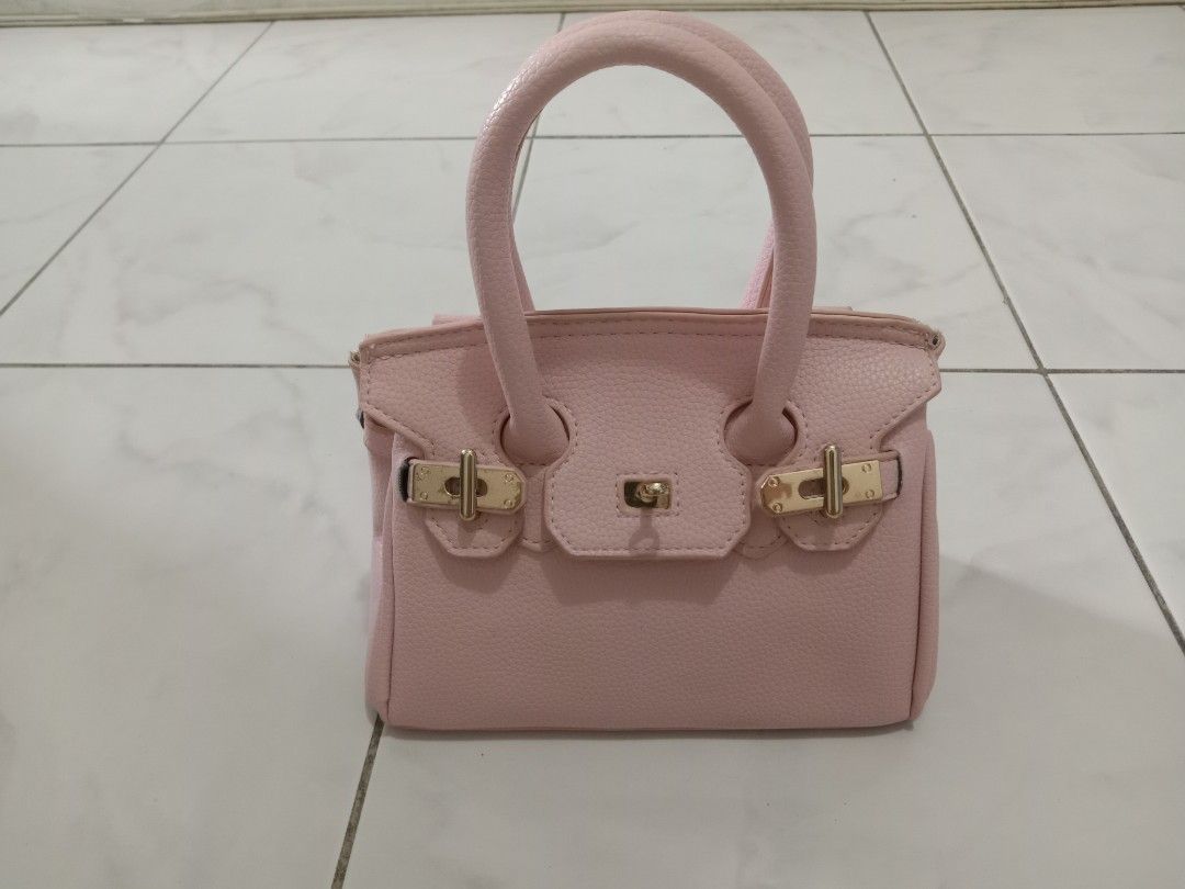 Pink Mini Handbag with Gold Hardware (Category: Luxury Bags & Wallets) located in Manila. Submitted by akira1818 (Listing ID 1455909137, Image 1). Description: - Adorable pink mini handbag - Elegant gold hardware details on clasp and side rings - Lined with soft grey fabric inside - Features convenient top handles for carrying - Compact size, ideal for carrying your essentials.
