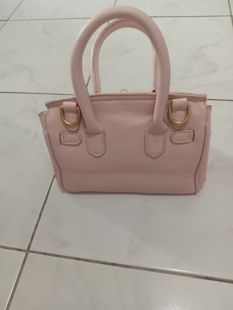 Pink Mini Handbag with Gold Hardware (Category: Luxury Bags & Wallets) located in Manila. Submitted by akira1818 (Listing ID 1455909137, Image 2). Description: - Adorable pink mini handbag - Elegant gold hardware details on clasp and side rings - Lined with soft grey fabric inside - Features convenient top handles for carrying - Compact size, ideal for carrying your essentials.