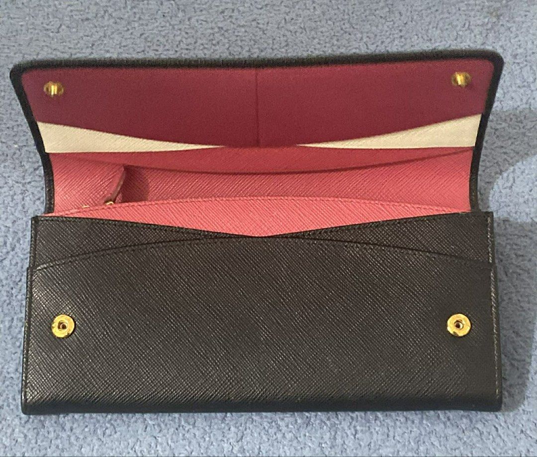 Prada Saffiano Leather Continental Flap Wallet (Category: Luxury Bags & Wallets) located in Manila. Submitted by alldayshoppinggirl (Listing ID 1455870261, Image 2). Description: Prada Saffiano Leather Continental Flap Wallet in black with gold-tone hardware lettering. Material: Crafted from Prada’s signature scratch-resistant cross-hatch embossed Saffiano calf leather. Design: Features a foldover flap with a press-stud snap closure and the iconi