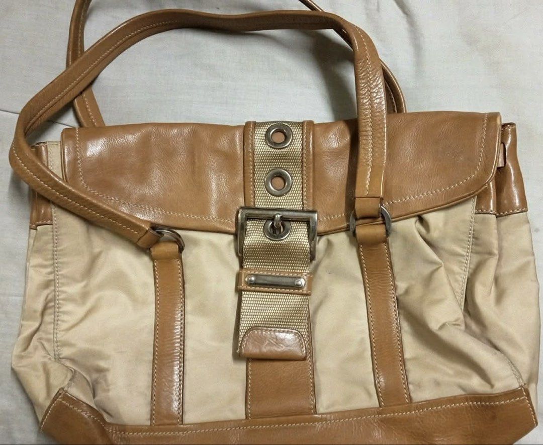 PRADA TESSUTO NYLON VINTAGE SHOULDER BAG (Category: Shoulder Bags) located in Binmaley. Submitted by vanilla_style (Listing ID 1456008541, Image 1). Description: Made in Italy Color: Beige Nylon Body / Tan Brown Leather Trim Material: Durable Lightweight Nylon + Genuine Calfskin Leather Hardware: Silver-Tone Buckle & Accents ✅ Condition: Pre-loved / Good Vintage Condition Structurally Perfect — No Holes, Tears, or Major Damage Clean Inside & Out 