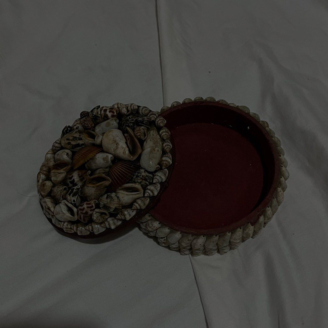 Seashell Decorated Trinket Box with Lid (Category: Storage Boxes & Baskets) located in Bayambang. Submitted by dumpieplings_ (Listing ID 1456015754, Image 1). Description: - Round decorative box covered in small seashells - Lid also adorned with a variety of shells - Reddish-brown interior - Ideal for storing small items or as a decorative accent - Brings a coastal vibe to any room rfs: decluttering.