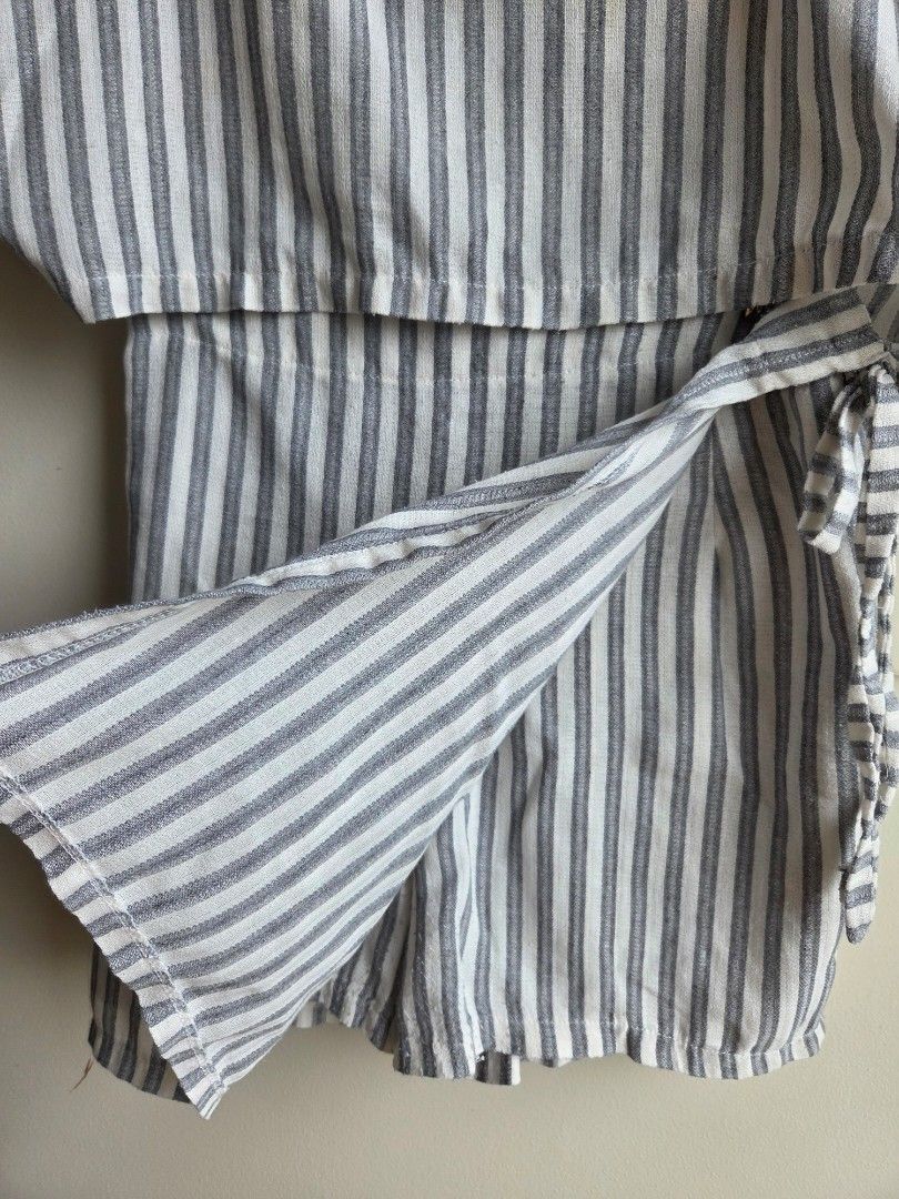 Striped Button-Up Shirt with Tie Detail (Category: Shirts) located in Quezon City. Submitted by strwbry.ph (Listing ID 1455906967, Image 2). Description: - Stylish grey and white stripe pattern - Classic button-up front - Unique tie detail at the collar - Long sleeves with cuffs - Lightweight, breathable fabric (feels like linen or cotton blend) - Versatile for casual to smart-casual outfits - Effortless to style - Fits M to L.
