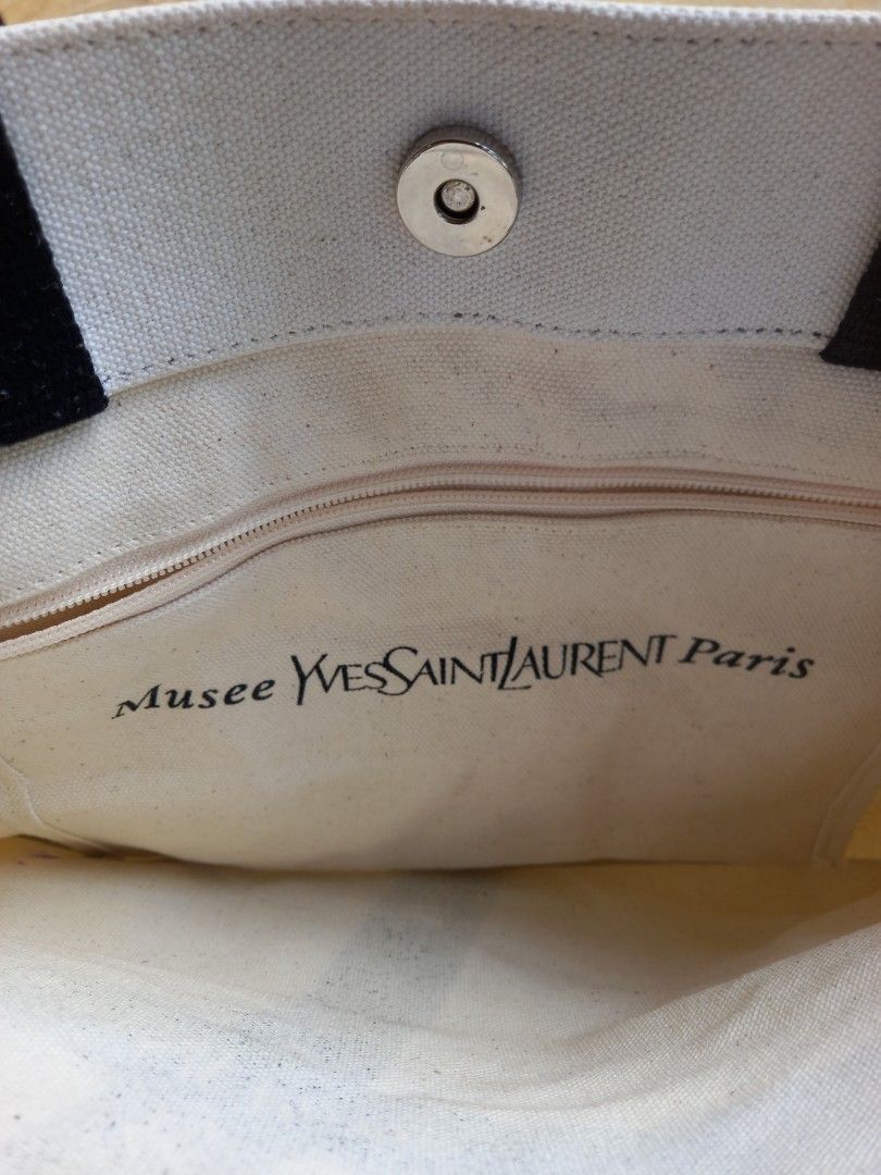 Yves Saint Laurent Musee Tote Bag (Category: Luxury Bags & Wallets) located in Davao. Submitted by kirk214red-50020 (Listing ID 1455891985, Image 3). Description: - White canvas tote bag - Black Yves Saint Laurent ribbon detail - Magnetic snap closure - Interior zippered pocket - Perfect for everyday use or travel.