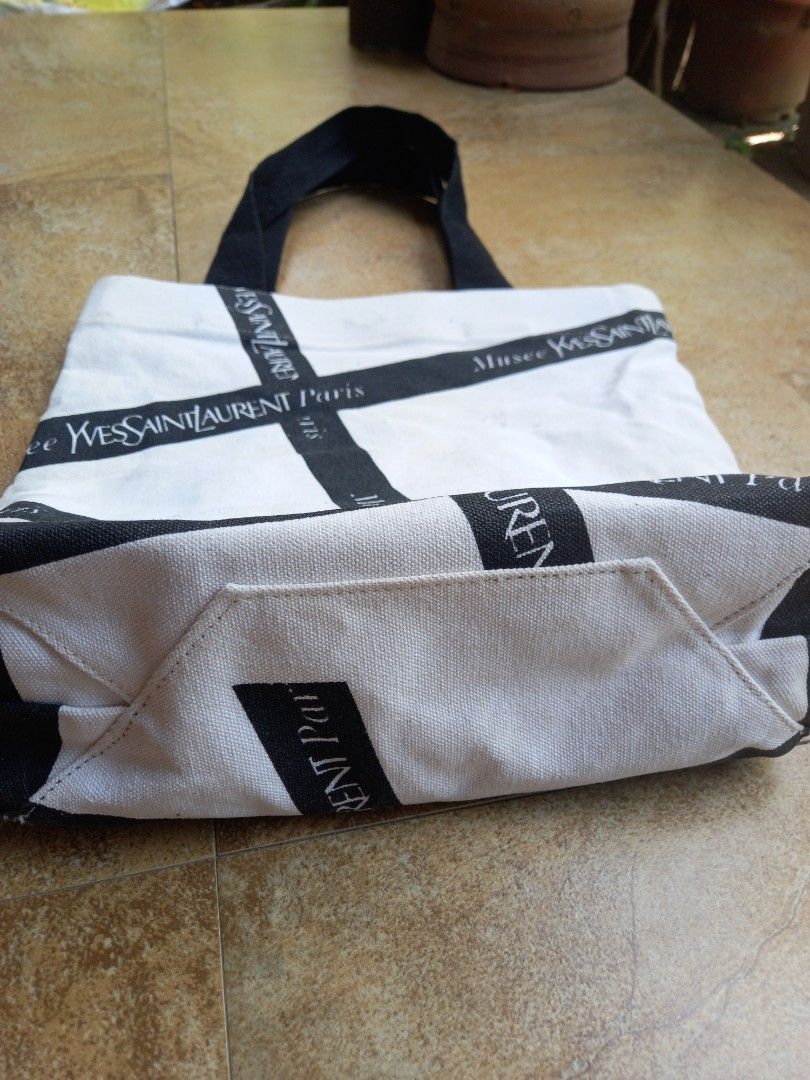 Yves Saint Laurent Musee Tote Bag (Category: Luxury Bags & Wallets) located in Davao. Submitted by kirk214red-50020 (Listing ID 1455891985, Image 2). Description: - White canvas tote bag - Black Yves Saint Laurent ribbon detail - Magnetic snap closure - Interior zippered pocket - Perfect for everyday use or travel.