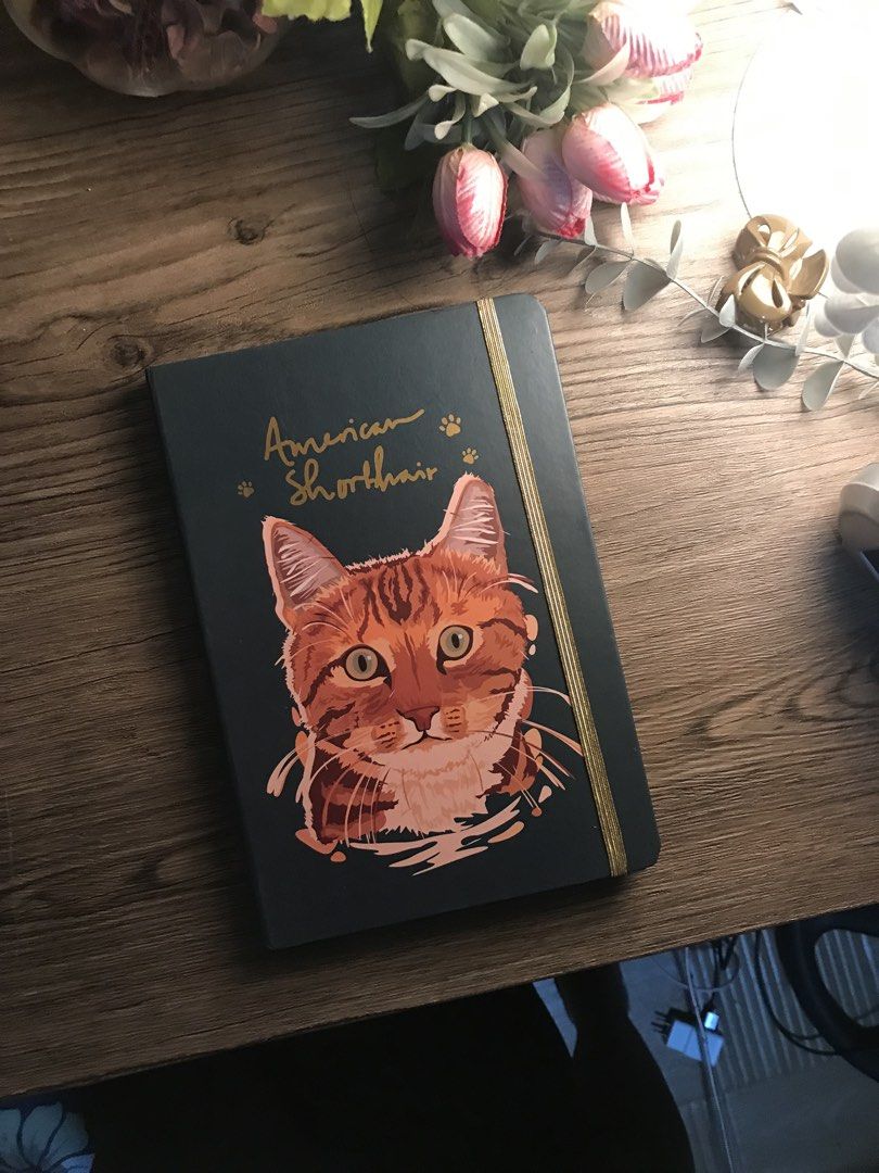 American Shorthair Cat Notebook Journal (Category: Stationery & School Supplies) located in Paranaque City. Submitted by mozza_1 (Listing ID 1456221596, Image 1). Description: BRAND NEW and NEVER USED Bought for 350+ php - Adorable American Shorthair cat design on the cover. - Stylish dark green cover with a gold elastic closure. - Lined pages inside, perfect for writing. - Great for taking notes, journaling, or as a diary. - A must-have for any 