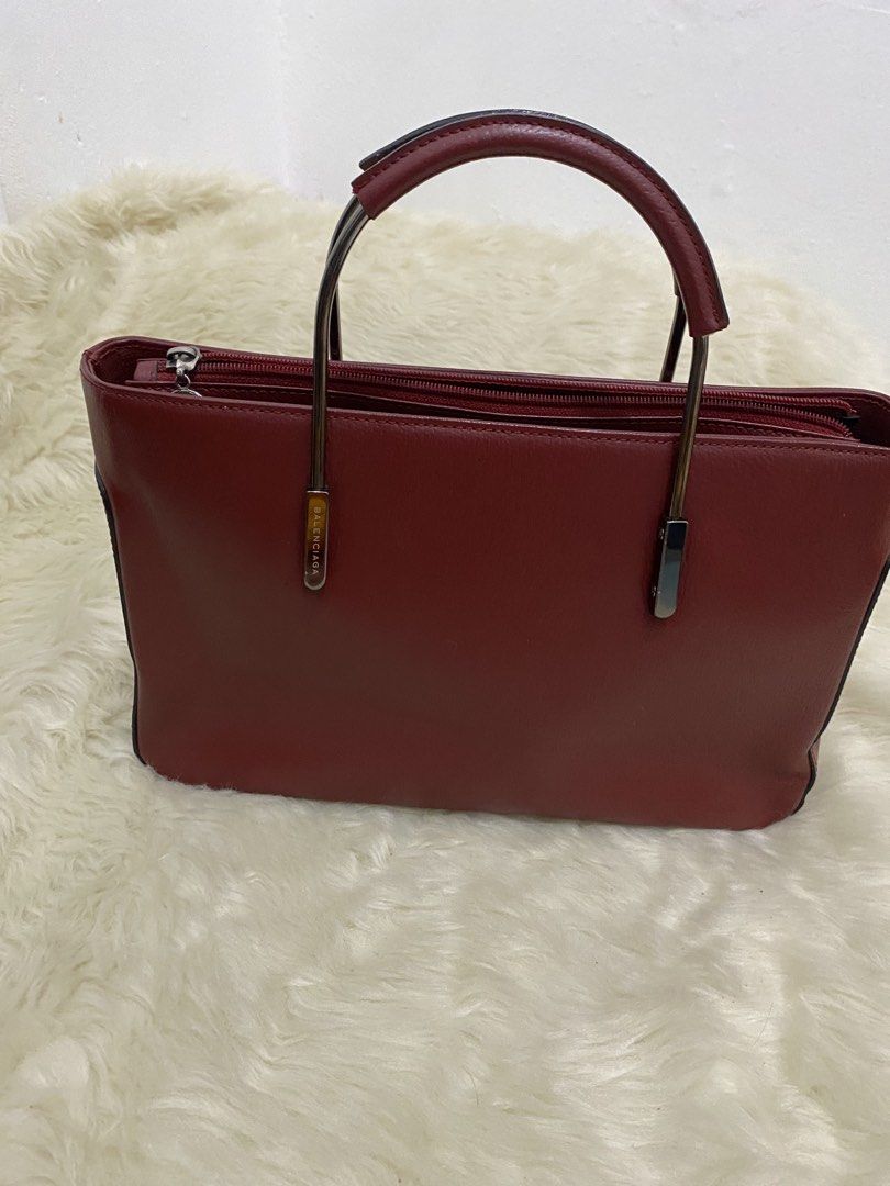 Balenciaga bag (Category: Luxury Bags & Wallets) located in San Antonio. Submitted by clinicallycute_. (Listing ID 1456177316, Image 1). Description: - Classic red leather handbag from Balenciaga Paris - Secure zip closure - Stylish metal handles - Spacious interior with multiple compartments - Clean lining - Ideal for everyday use.