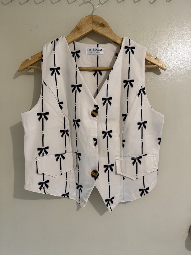 BKK Finds: Wisdom Studio Ribbon Printed Co-Ord Set (Category: Sets or Coordinates) located in Mandaluyong City. Submitted by anne_manda (Listing ID 1456079474, Image 2). Description: **Worn only once** Features an off-white/cream base adorned with a dainty black bow and pinstripe print. The vest has a flattering V-neck cut with tortoiseshell button details, while the high-waisted wide-leg trousers offer a sleek, elongated silhouette with a comfor