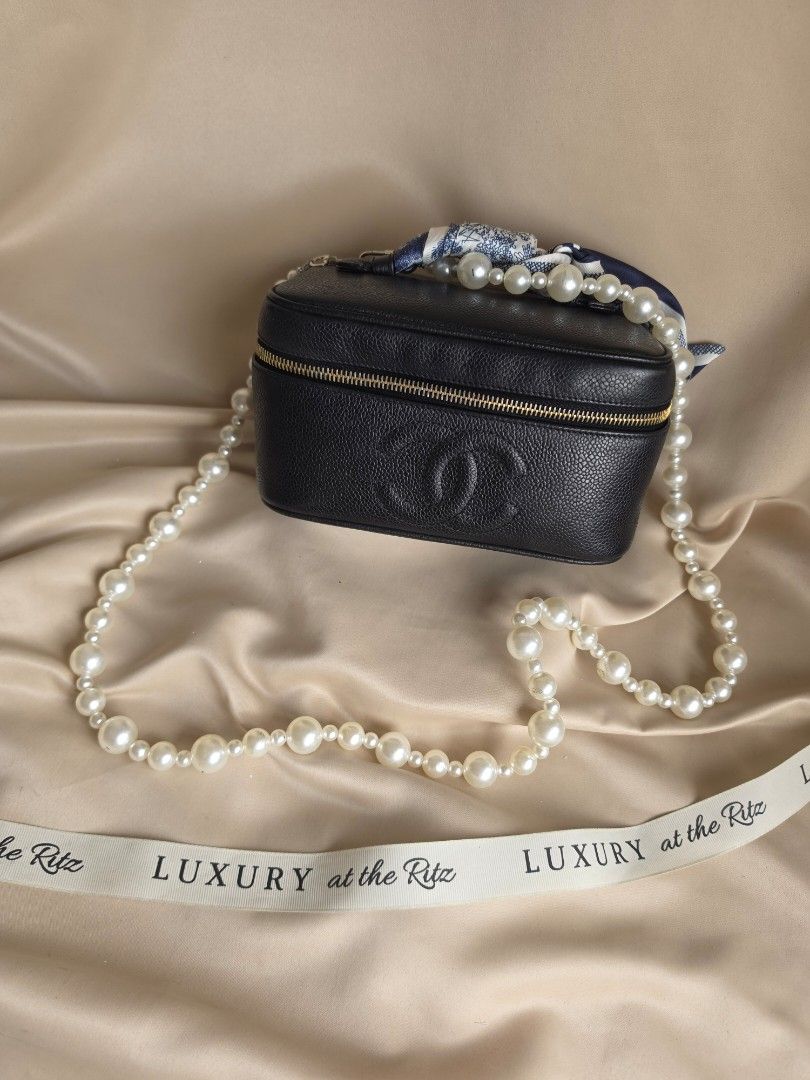 Chanel Black Caviar Vanity Case Bag with Pearl Strap (Category: Luxury Bags & Wallets) located in Makati City. Submitted by luxritz (Listing ID 1456065957, Image 1). Description: - Classic Chanel black caviar leather vanity case - Iconic embossed CC logo on the front - Comes with a beautiful pearl strap - Includes a silk scarf tied to the handle - Gold tone zipper closure - Perfect for a night out or as a statement piece Comes with Card and Box. 