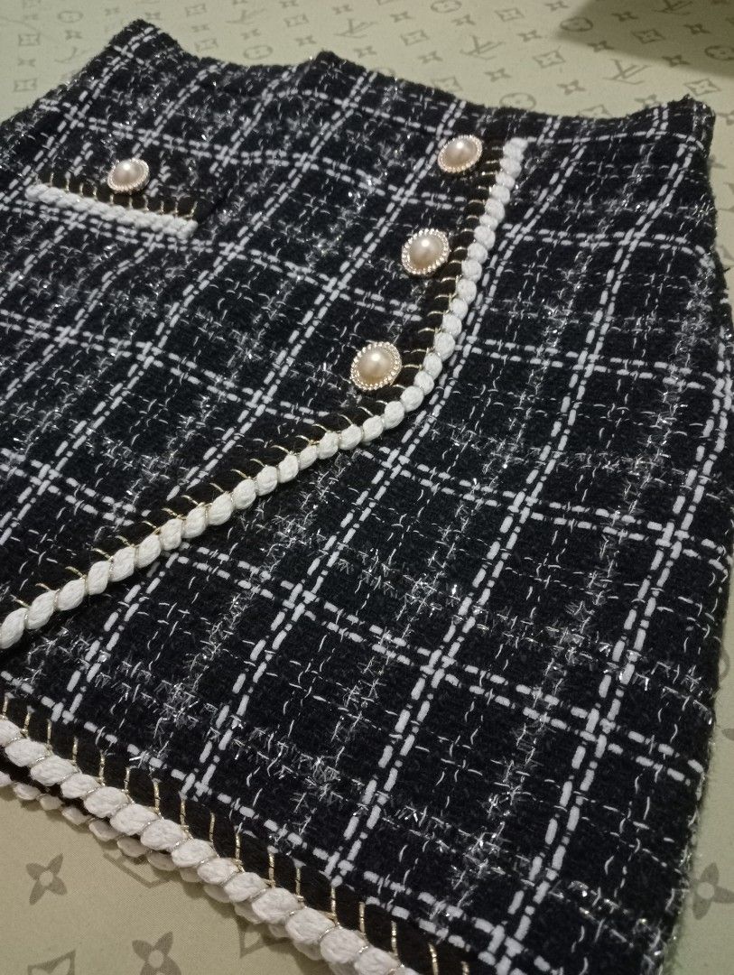 Classic Tweed Checkered Mini Skort (Category: Skirts) located in Naga. Submitted by declutter_it (Listing ID 1456210964, Image 3). Description: Luxury-style tweed, pearl buttons, braided trim, built-in shorts. Flattering A-line fit — great for smart casual, dates, or school. Flaws: Very faint tiny snag; no holes/rips/loose buttons. Pre-loved & looks like new SIZE: Medium Waist: 27-28 inches Length: 14 inches.
