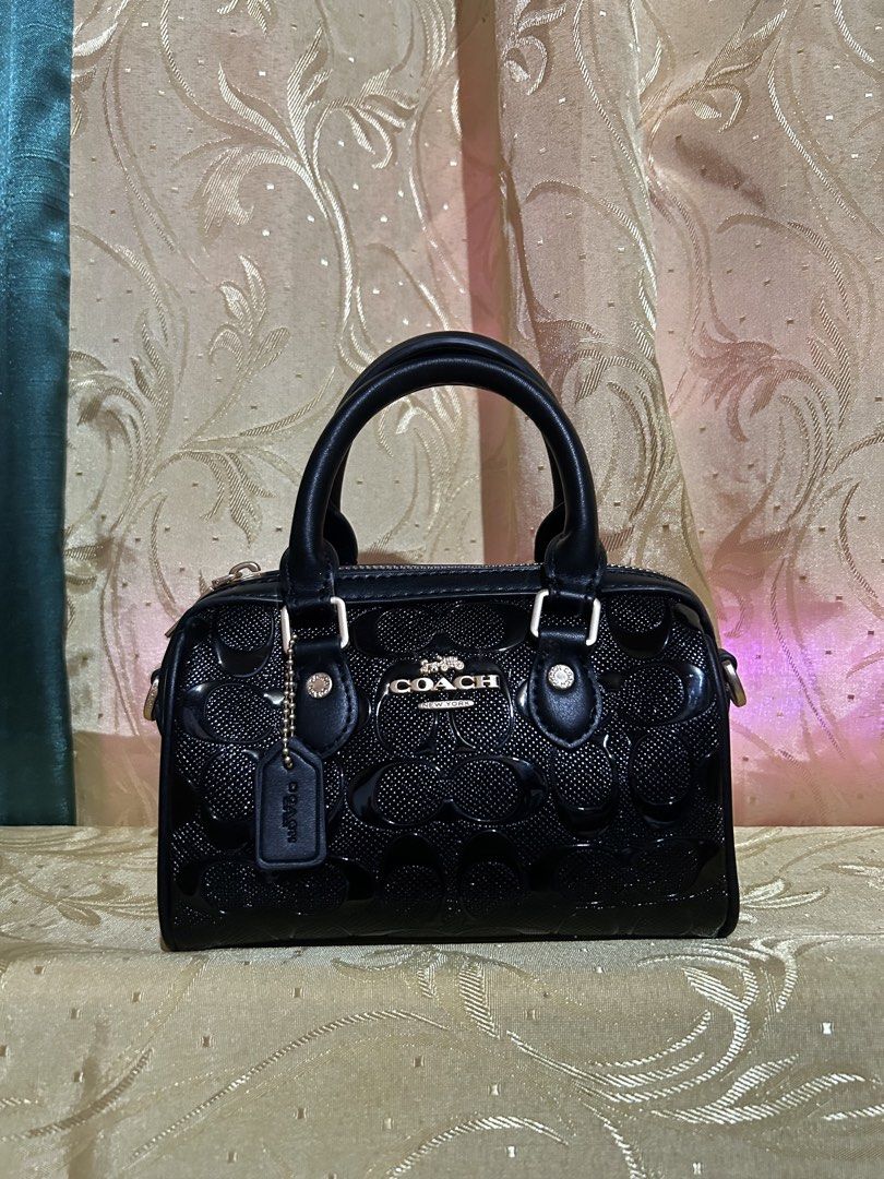 Coach Black Monogram Patent Leather Mini Barrel Bag (Category: Luxury Bags & Wallets) located in Caloocan City. Submitted by coolwhale-76ba (Listing ID 1456093929, Image 1). Description: - Coach black patent leather mini barrel bag - All-over signature monogram pattern - Top handles - Detachable crossbody strap - Gold hardware details - Zipper closure - Interior slip pocket - Ideal for carrying essentials - N.G.A..