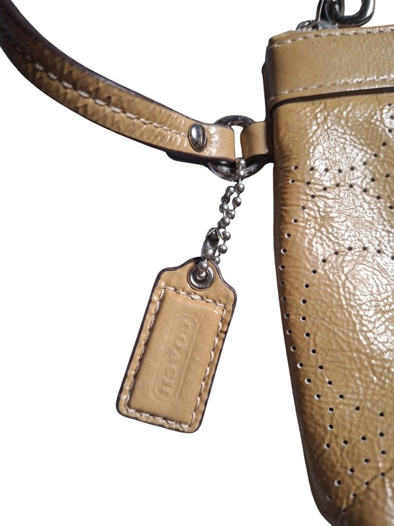 Coach Patent Leather Perforated Wristlet Pouch Tan (Category: Purses & Pouches) located in San Juan (Cabalian). Submitted by ec8thrift (Listing ID 1456096719, Image 3). Description: - Coach wristlet pouch - Patent leather with perforated pattern - Secure zip closure - Detachable wrist strap for convenience - Comes with original Coach care card and tag - Ideal size for carrying essentials.