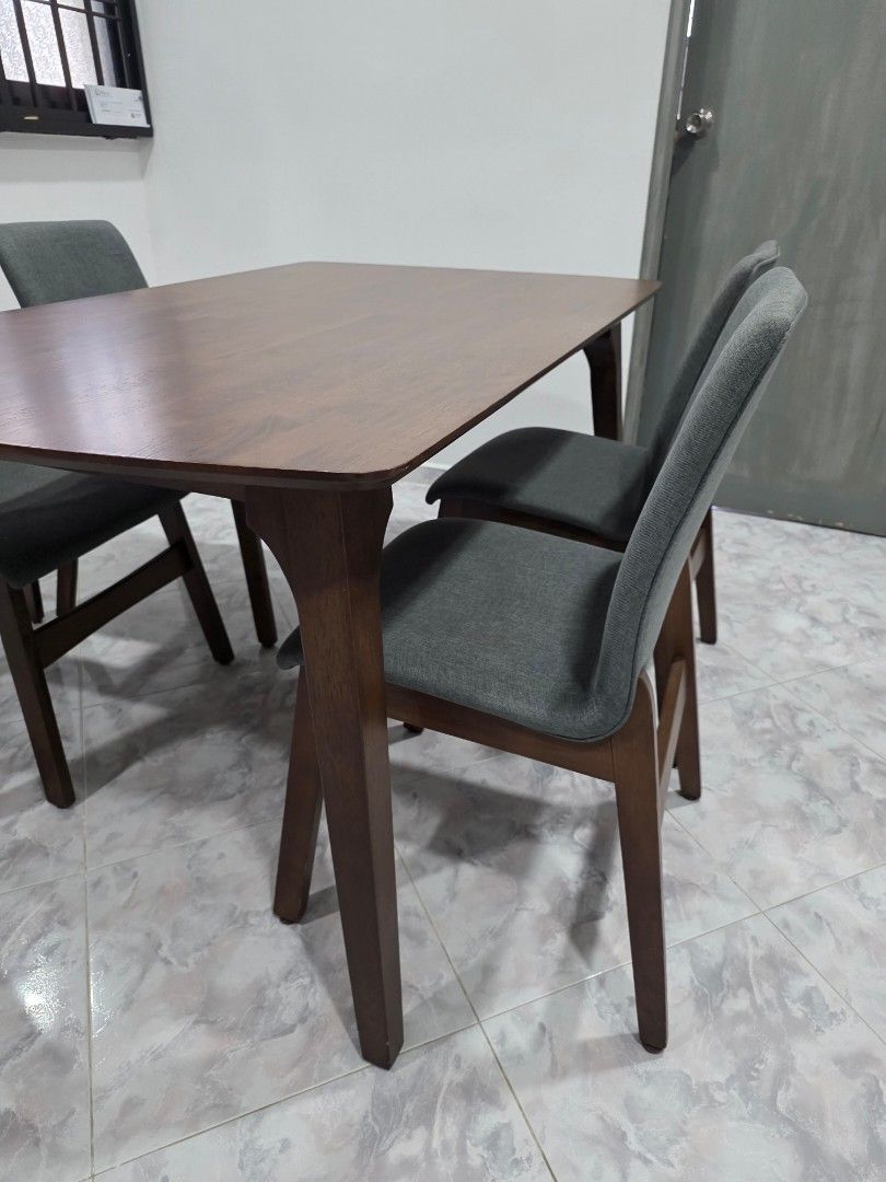 Dining Table set (Category: Tables & Sets) located in Singapore. Submitted by wani.s (Listing ID 1456062303, Image 3). Description: - Wooden dining table with warm wood tone -Dimension 150cm (L) x 90cm (W) x 75cm (H) - Slightly curved rectangular shape - Seats four comfortably - Includes four grey fabric chairs 45cm -Sold as a complete set will not be dismantled Arrange your own transport/pick up Letting go urgently.