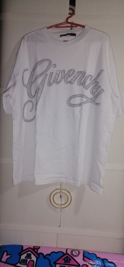 Givenchy Paris White Rhinestone Logo T-shirt (Category: Tshirts & Polo Shirts ) located in Quezon City. Submitted by rolenalma (Listing ID 1456123424, Image 1). Description: - Authentic Givenchy Paris T-shirt - Features a sparkling rhinestone logo on the front - Back design: 'Never Stop Dreaming' graphic with a smiley face - Ideal for casual and everyday wear - Please check all photos for detailed condition.