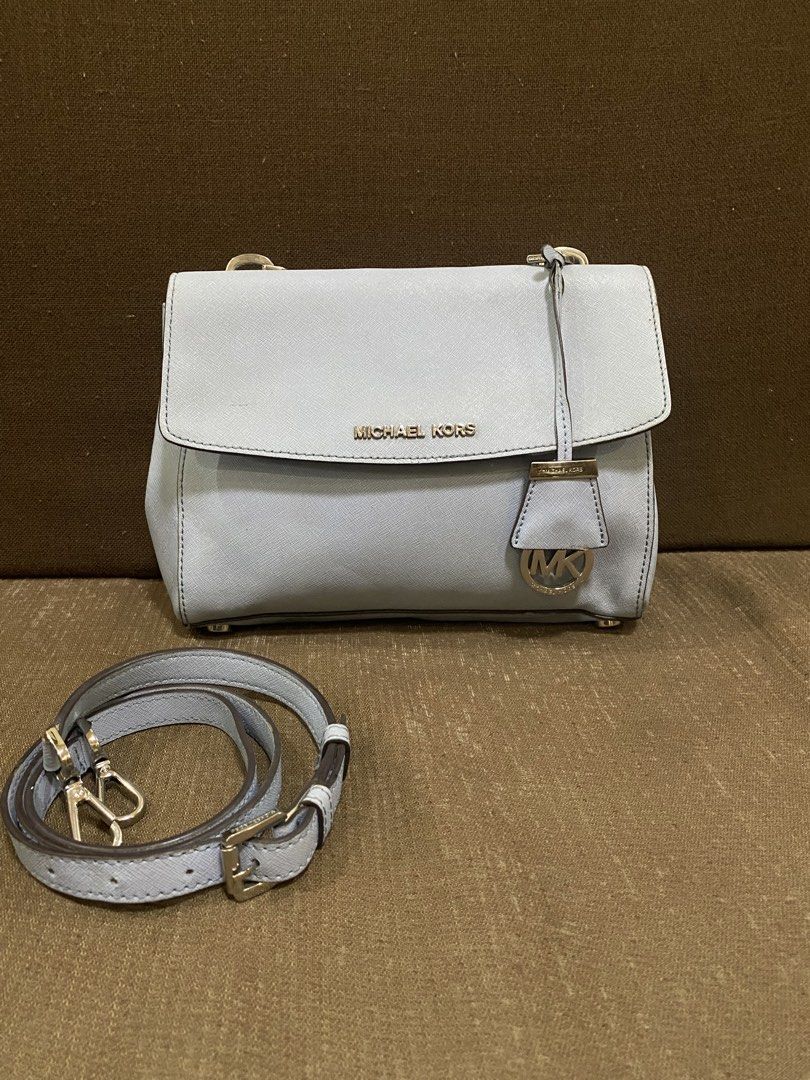michael kors bag (Category: Luxury Bags & Wallets) located in San Antonio. Submitted by pixiechromzzz (Listing ID 1456130033, Image 3). Description: - Genuine light blue leather Michael Kors bag - Elegant gold hardware details - Secure flap closure - Includes a detachable light blue crossbody strap with grey trim - Ample interior space for your essentials - Ideal for everyday wear and versatile styling.
