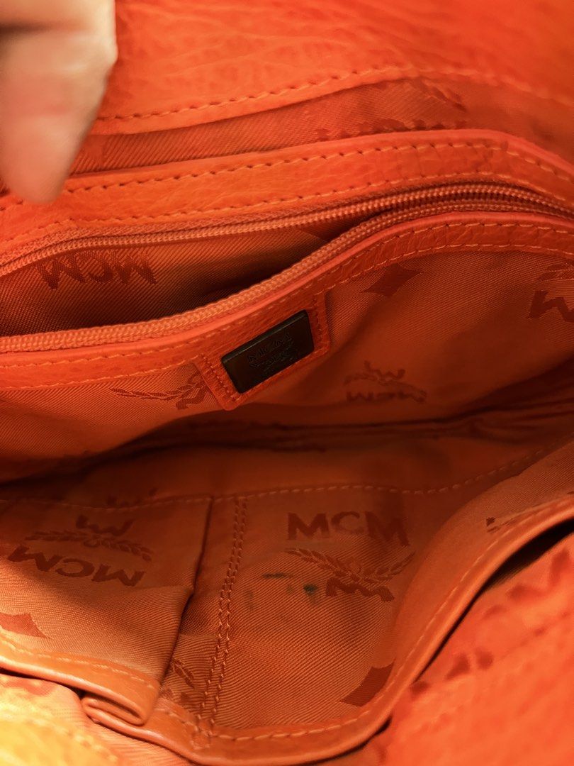 Orange MCM Leather Shoulder Bag (Category: Luxury Bags & Wallets) located in Bayombong. Submitted by jheizzdomingo (Listing ID 1456175692, Image 3). Description: - Authentic orange leather MCM shoulder bag - Iconic MCM logo on front flap and interior - Multiple interior compartments for organization - Convenient interior zippered pocket - Elegant gold hardware details - Adjustable strap for comfortable wear.