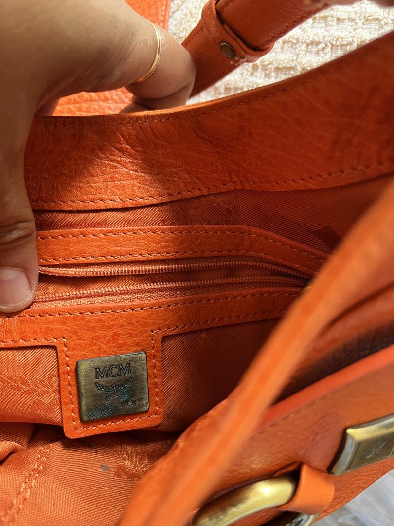 Orange MCM Leather Shoulder Bag (Category: Luxury Bags & Wallets) located in Bayombong. Submitted by jheizzdomingo (Listing ID 1456175692, Image 2). Description: - Authentic orange leather MCM shoulder bag - Iconic MCM logo on front flap and interior - Multiple interior compartments for organization - Convenient interior zippered pocket - Elegant gold hardware details - Adjustable strap for comfortable wear.