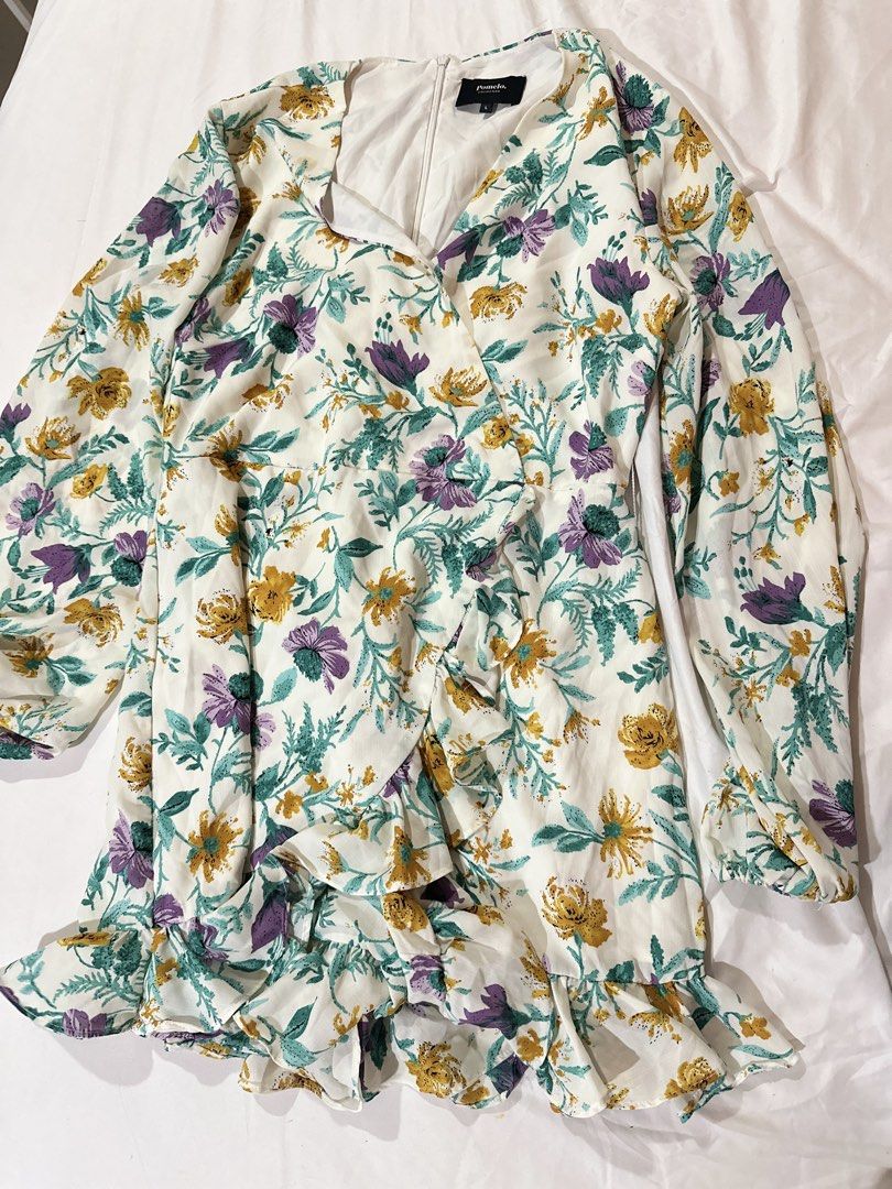 Pomelo Floral Wrap Dress Size L (Category: Dresses) located in Quezon City. Submitted by aleezy (Listing ID 1456098342, Image 1). Description: - White wrap dress with a vibrant floral print - Features purple, yellow, and green flowers - Long sleeves with ruffled cuffs - Zipper closure at the back - Ruffled hemline for a stylish touch - Ideal for casual outings or events.