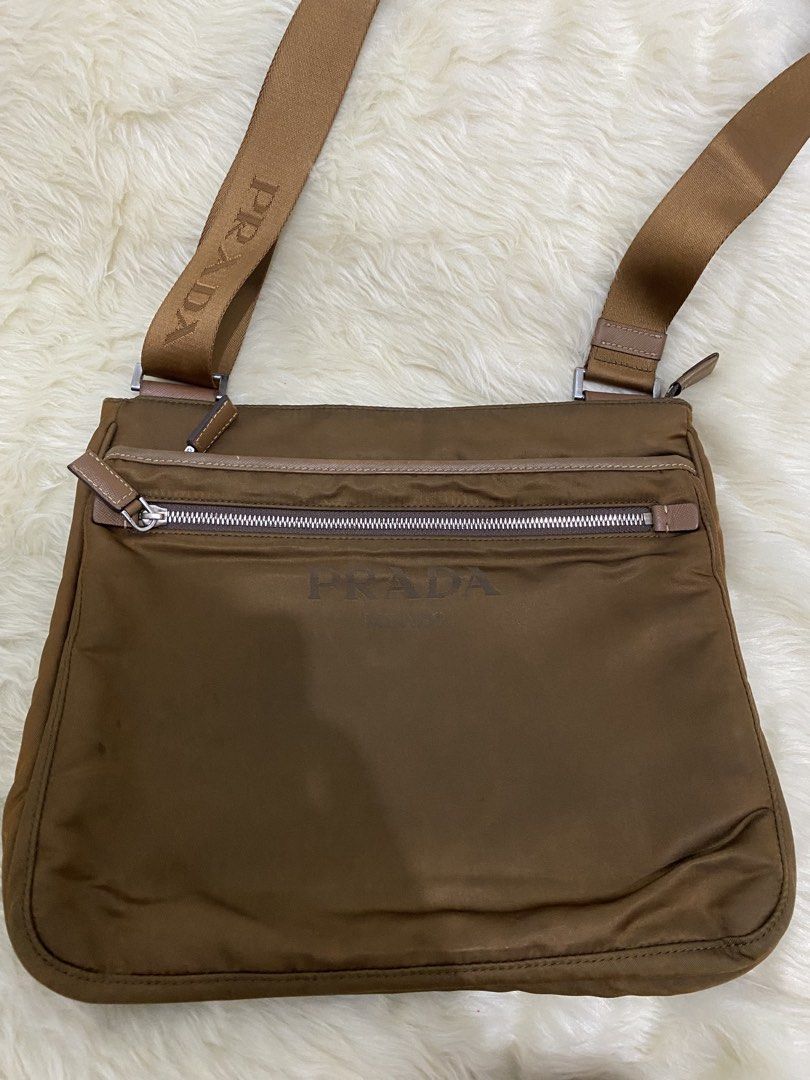 Prada Nylon Crossbody Bag (Category: Luxury Bags & Wallets) located in San Antonio. Submitted by clinicallycute_. (Listing ID 1456176587, Image 3). Description: - Prada crossbody bag - Material: Nylon with leather trim - Features: Front zip pocket, interior zip pocket - Strap: Adjustable with Prada branding negotiable.