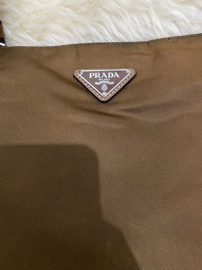 Prada Nylon Crossbody Bag (Category: Luxury Bags & Wallets) located in San Antonio. Submitted by clinicallycute_. (Listing ID 1456176587, Image 2). Description: - Prada crossbody bag - Material: Nylon with leather trim - Features: Front zip pocket, interior zip pocket - Strap: Adjustable with Prada branding negotiable.