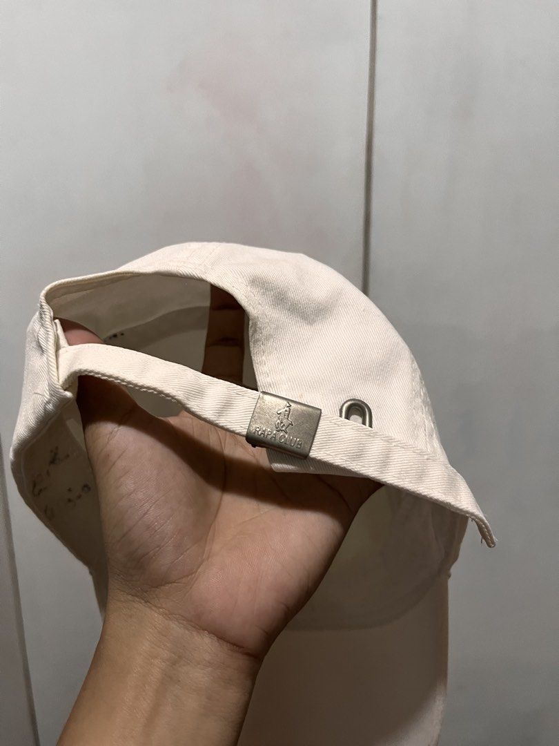 Rafa Club White Baseball Cap with Embroidered Logo (Category: Caps & Hats) located in Buenavista. Submitted by ian14215 (Listing ID 1456076939, Image 3). Description: - White baseball cap from Rafa Club - Features a navy blue embroidered logo on the front - Adjustable strap with metal buckle at the back - Note: Some faint marks on the brim (please check photos) - Perfect for casual everyday wear.