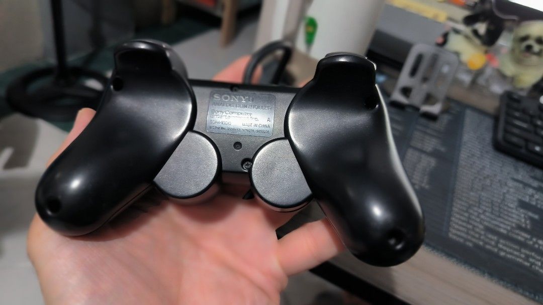 Sony PS2 Dual Shock 2 Controller (Category: Controllers) located in Bulacan. Submitted by tripledouble532 (Listing ID 1456092958, Image 2). Description: For vintage collection: Classic black Sony PlayStation 2 DualShock 2 Controller featuring twin analog sticks, a directional pad, and standard action buttons. [1] Type: Wired analog controller with force-feedback vibration Compatibility: Designed primarily for the PlayStation 2 and backward compat