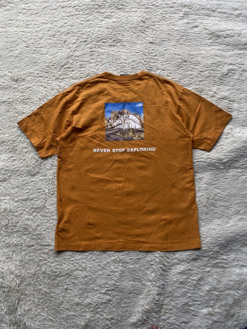 The North Face "Never Stop Exploring" Graphic T-Shirt (Category: Tshirts & Polo Shirts ) located in Cebu City. Submitted by deethirdd (Listing ID 1456186713, Image 1). Description: - Brand: The North Face - Color: light brown - Design: Graphic print on back with "Never Stop Exploring" slogan, small logo on front chest - Material: Comfortable cotton - Style: Great for casual wear.