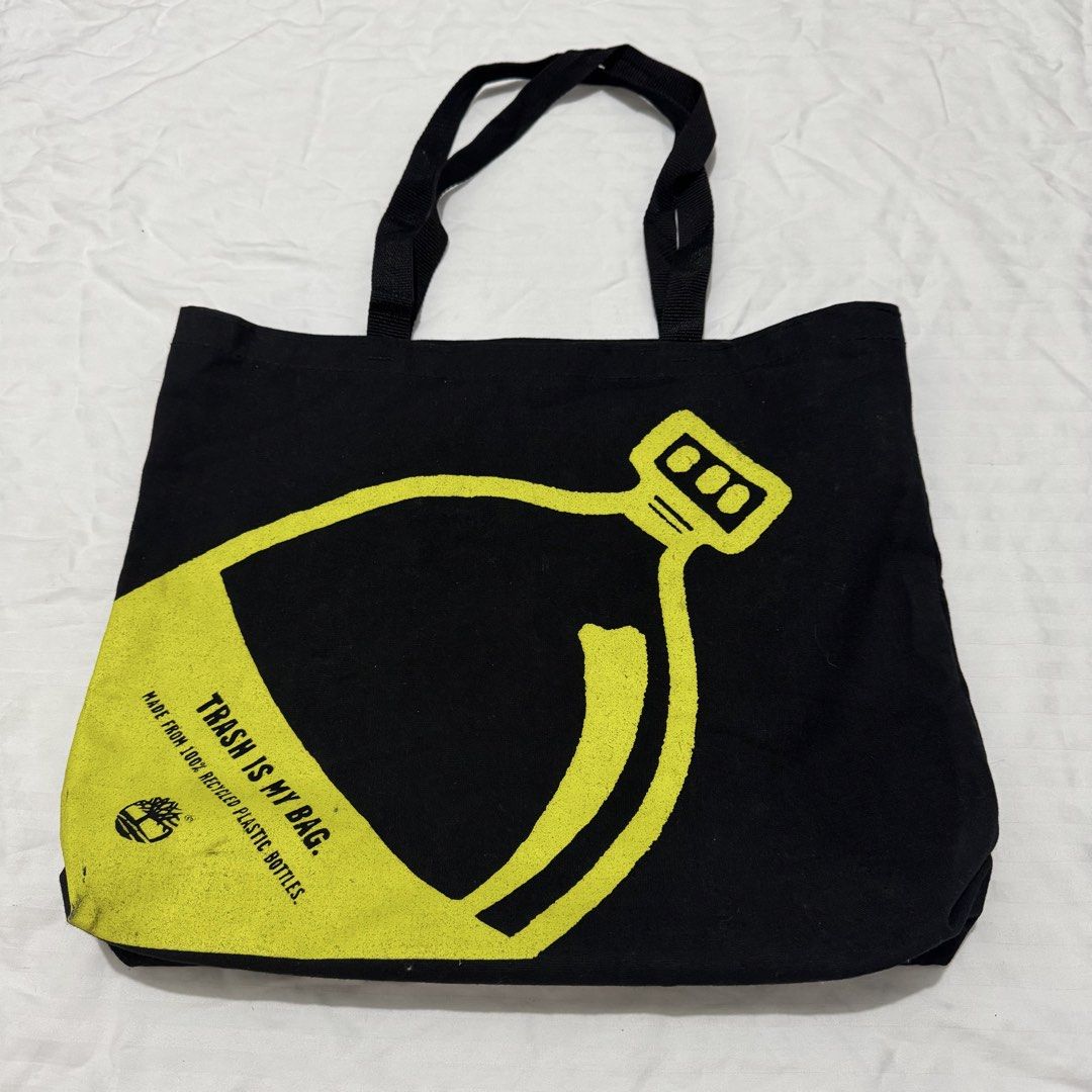 TIMBERLAND TOTE BAG (Category: Tote Bags) located in Pasig City. Submitted by jaaard (Listing ID 1456195358, Image 1). Description: - Brand: Timberland - Type: Tote Bag - Design: "Trash is My Bag" slogan with bottle graphic - Material: 100% recycled plastic bottles - Interior: Lined with Timberland's environmental commitment message - Special Tag: "The Bott Bag™ Ask for it by name!".