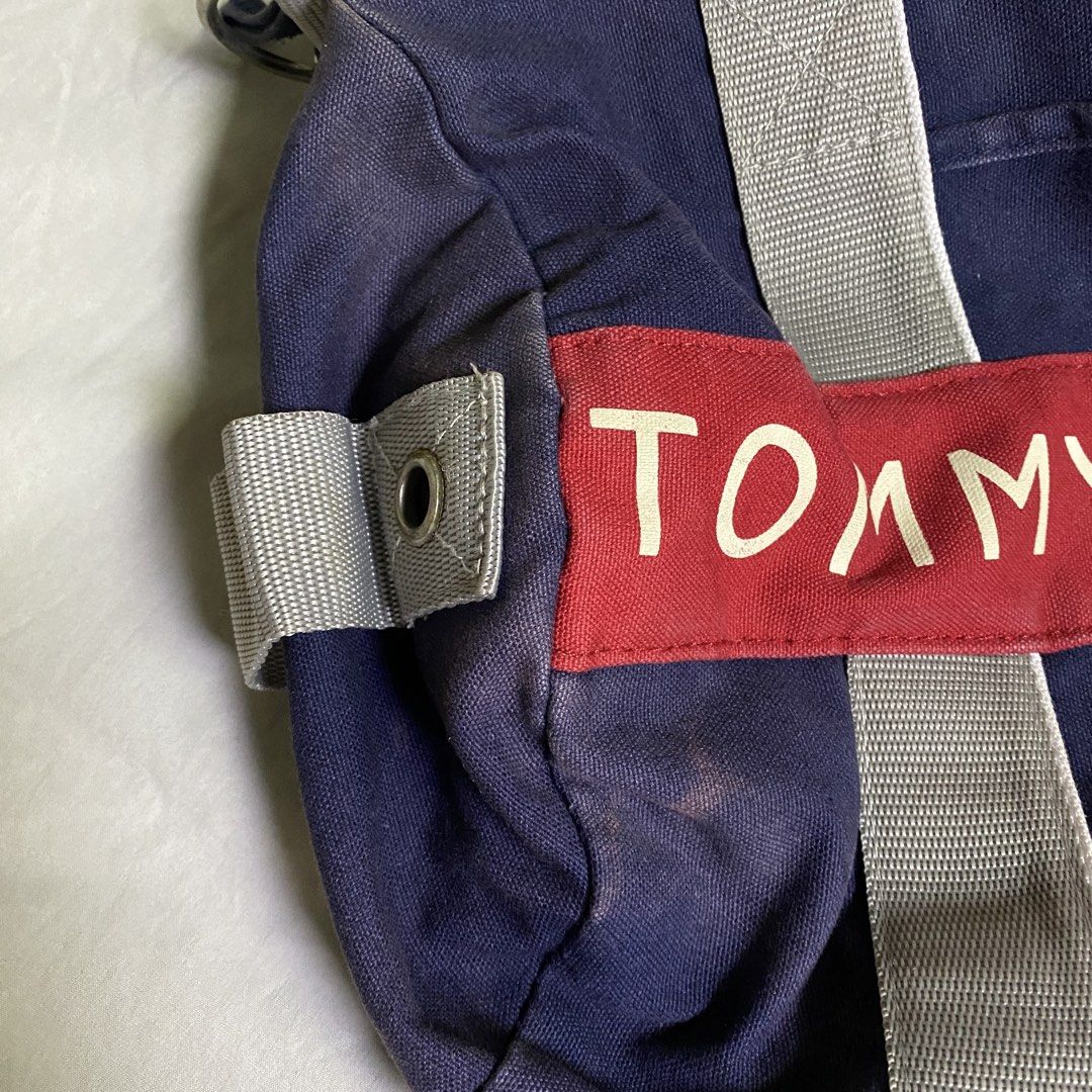 Tommy Hilfiger Navy Blue Duffle Bag with Shoulder Strap (Category: Shoulder Bags) located in Marikina City. Submitted by beeeekenneth (Listing ID 1456140868, Image 3). Description: - Navy blue Tommy Hilfiger duffel bag - Signature red and white logo band on front - Top handles and detachable shoulder strap - Zipped main compartment - Front zip pocket - Small side pockets - Ideal for gym or weekend trips -sunfade issue Location: Marikina + we can 