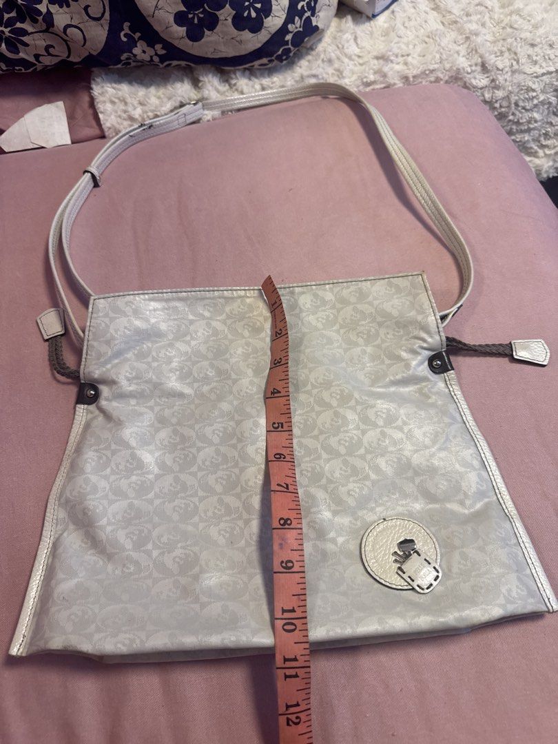 2027 Pelle Borse White Monogram Shoulder Bag (Category: Luxury Bags & Wallets) located in Silang. Submitted by sari2bilina (Listing ID 1456368815, Image 2). Description: - Stylish white shoulder bag - Features a repeating monogram pattern - Elegant leather trim - Secure circular clasp closure - Adjustable strap for comfort - Dimensions: Approximately 12 inches wide x 10 inches tall - Interior lining: Grey - Includes a small leather tag with brand