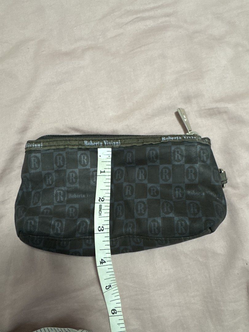 2027 Roberta Viviani Monogram Pouch (Category: Luxury Bags & Wallets) located in Silang. Submitted by sari2bilina (Listing ID 1456336838, Image 1). Description: - Dark grey pouch with Roberta Viviani monogram pattern - Zipper closure for secure storage - Small ring on the side for easy attachment - Dimensions: Approximately 8 inches long and 2 inches wide - Ideal for organizing small items like coins, keys, or makeup.