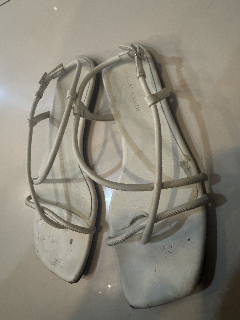 37 Charles & Keith White Strappy Flat Sandals Size 37 (Category: Flats & Sandals) located in Manila. Submitted by decluterthings888 (Listing ID 1456360179, Image 2). Description: - Brand: Charles & Keith - Color: White - Style: Strappy sandals - Toe Shape: Square toe - Features: Adjustable ankle strap - Condition: Soles show some wear - Occasion: Great for casual outings.