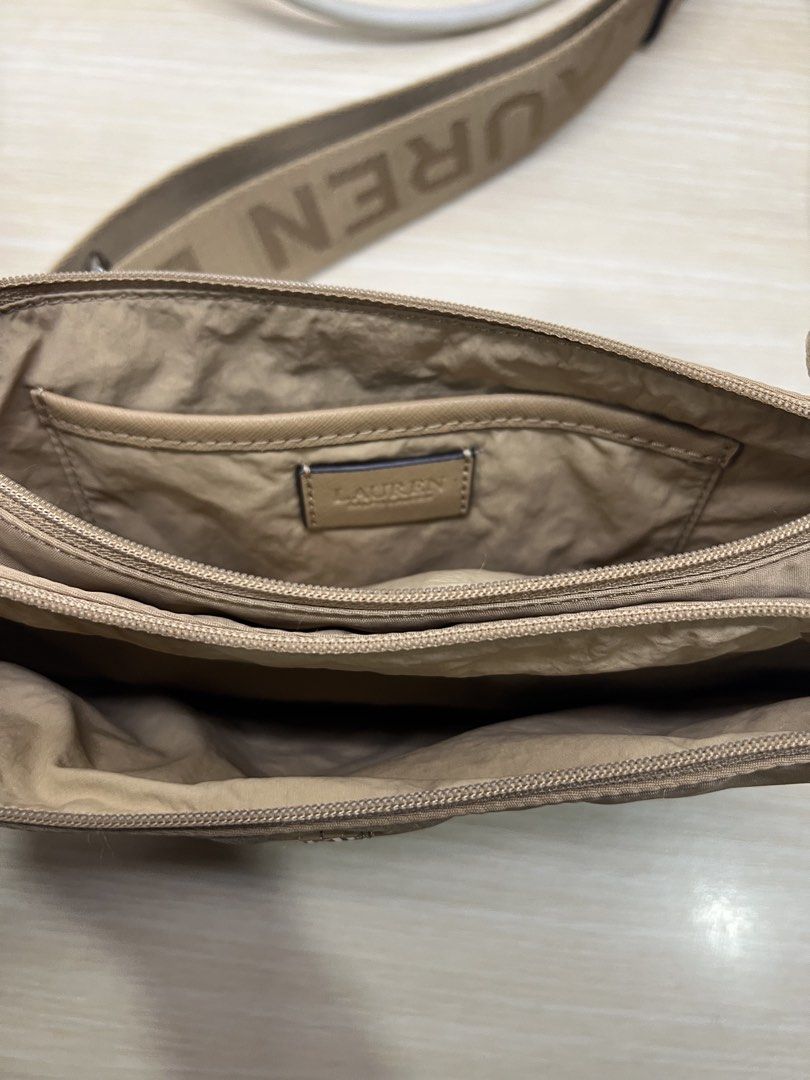 Authentic Ralph Lauren Nylon Crossbody Bag Tan (Category: Cross-body Bags) located in San Juan City. Submitted by rctdeclutter_ (Listing ID 1456346331, Image 2). Description: - Authentic Lauren Ralph Lauren Tan crossbody bag - Features the signature RL logo on the front - Strap printed with 'Ralph Lauren' name - Multiple interior compartments for organization - Durable nylon material with stylish leather trim - Care instructions included on tag -