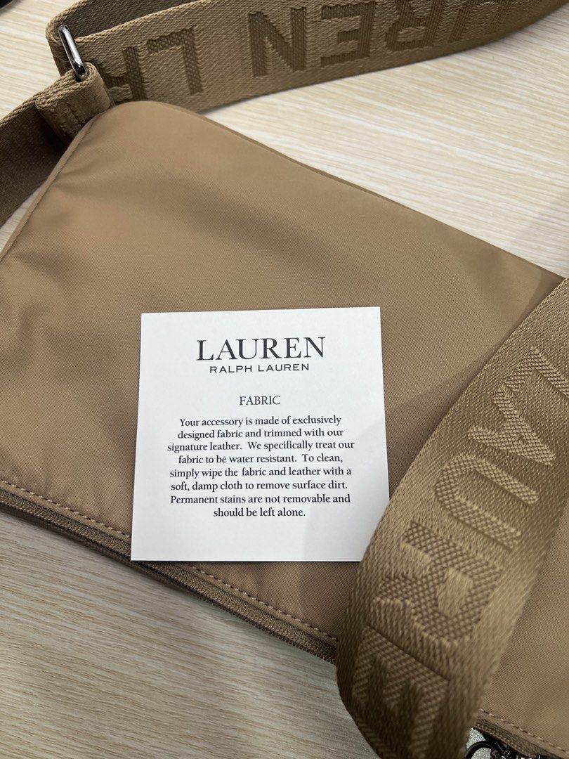 Authentic Ralph Lauren Nylon Crossbody Bag Tan (Category: Cross-body Bags) located in San Juan City. Submitted by rctdeclutter_ (Listing ID 1456346331, Image 3). Description: - Authentic Lauren Ralph Lauren Tan crossbody bag - Features the signature RL logo on the front - Strap printed with 'Ralph Lauren' name - Multiple interior compartments for organization - Durable nylon material with stylish leather trim - Care instructions included on tag -