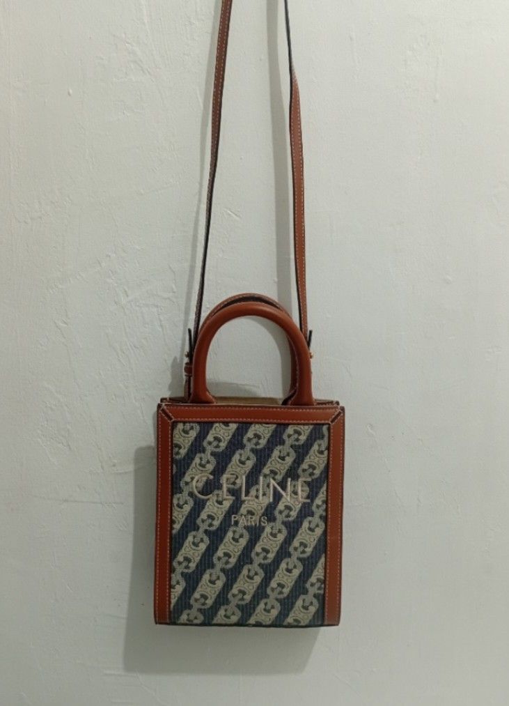 Celine Triomphe Canvas Mini Vertical Tote Bag (Category: Luxury Bags & Wallets) located in Manila. Submitted by eriiicaspage (Listing ID 1455586072, Image 2). Description: PreOwned LikeNew Lightly Used Celine Mini Canvas Leather trim Vertical Tote -Small Compact Size - Signature Triomphe canvas with brown leather trim - Top handles and detachable shoulder strap - Elegant gold hardware - Versatile for everyday or evening use - Spacious interior fo