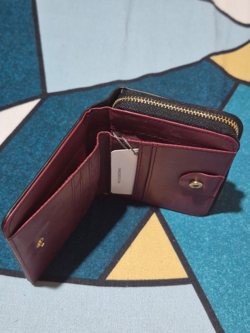 Charles & Keith Black Tri-fold Wallet (Category: Wallets & Card holders) located in Davao. Submitted by wangcollections (Listing ID 1456336224, Image 3). Description: - Brand: Charles & Keith (not guaranteed og) - Color: Black exterior, Burgundy interior - Style: Tri-fold wallet - Features: Card slots, coin pocket - Closure: Zipper - Ideal for: Everyday use.
