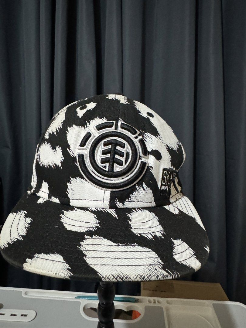 Element x New Era Skateboarding Cap (Category: Caps & Hats) located in Iligan City. Submitted by kitkatdeclutters (Listing ID 1456381856, Image 3). Description: - Brand: Element x New Era - Style: 59FIFTY Fitted Cap - Design: Black and white abstract print - Features: Embroidered Element logo on front, 'SKATE' text on side - Size: 7 1/2 (59.6cm) - Ideal for: Skaters, streetwear fans - Issue: has a written marker.