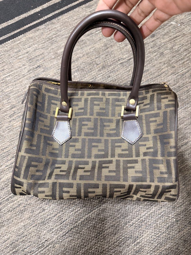 Fendi Zucca Canvas Boston Bag (Category: Luxury Bags & Wallets) located in Las Pinas. Submitted by robisean (Listing ID 1456336191, Image 1). Description: - Classic Fendi Boston bag - Iconic Zucca monogram canvas - Brown and tan colorway - Leather handles and trim - Zipper closure - Perfect for everyday essentials - Shows some signs of wear, but still has plenty of life left Issue Lining Degradation / Peeling Zipper and Plating Wear and Fading.