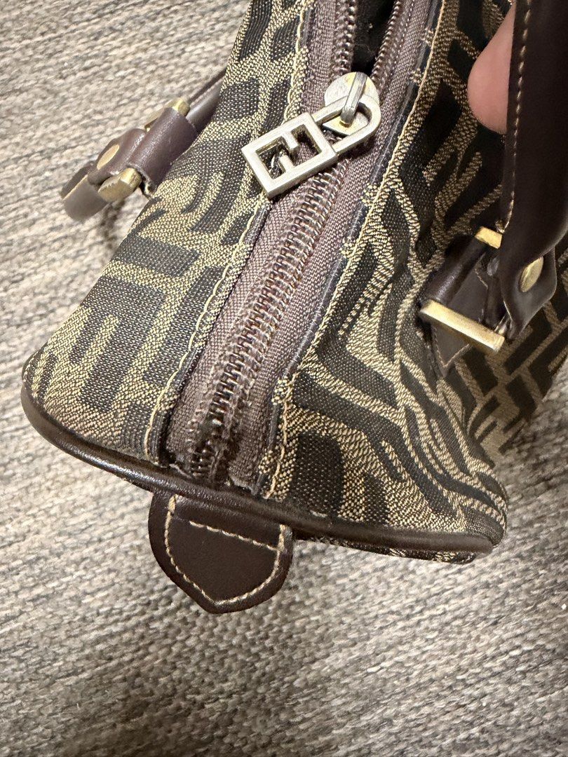 Fendi Zucca Canvas Boston Bag (Category: Luxury Bags & Wallets) located in Las Pinas. Submitted by robisean (Listing ID 1456336191, Image 3). Description: - Classic Fendi Boston bag - Iconic Zucca monogram canvas - Brown and tan colorway - Leather handles and trim - Zipper closure - Perfect for everyday essentials - Shows some signs of wear, but still has plenty of life left Issue Lining Degradation / Peeling Zipper and Plating Wear and Fading.