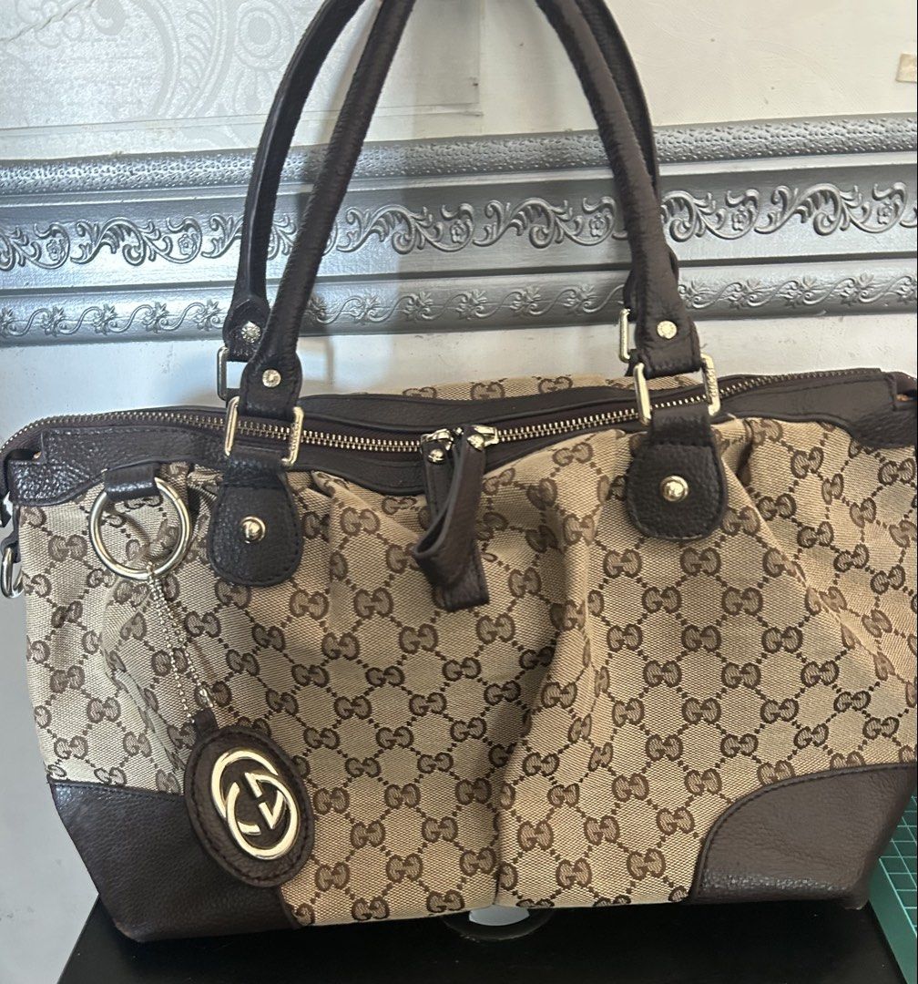 (RUSH! w/o charm) Gucci Sukey Hand Bag (Category: Luxury Bags & Wallets) located in San Jose del Monte. Submitted by declutteriri (Listing ID 1456296046, Image 3). Description: Material: GG canvas body with dark brown cowhide/calfskin leather trim and rolled leather top handles. Hardware: Polished light gold-tone or brass hardware. Signature Charm: Features the iconic interlocking G logo charm dangling from a ring on the front..
