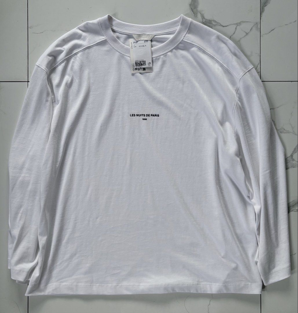 H&M White Long Sleeve "Les Nuits De Paris" (Category: Tshirts & Polo Shirts ) located in Manila. Submitted by izzmya (Listing ID 1456270279, Image 1). Description: - Brand: H&M - Color: White - Style: Long Sleeve - Graphic: "Les Nuits De Paris 1998" print on front - Neckline: Crew neck - Condition: Brand new with tags, but the tags are no longer attached - Material: Comfortable fabric It runs oversized Length: 28inch Width: 25inch.