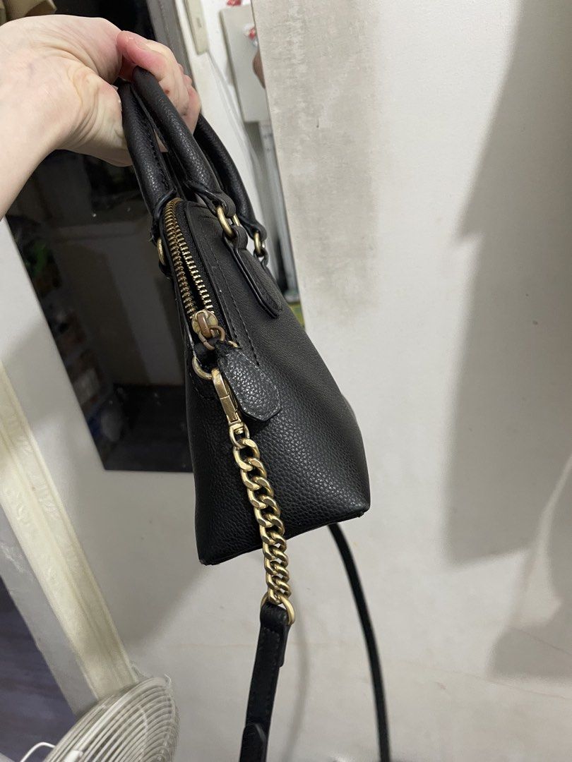 j.estina mini bag (Category: Luxury Bags & Wallets) located in Pasig City. Submitted by chrml (Listing ID 1456341411, Image 3). Description: - Brand: J.ESTINA - Color: Black - Style: Dome Satchel - Material: Pebble Leather - Hardware: Gold details, including chain strap accent - Straps: Top handles and detachable crossbody strap - Closure: Zipper - Size: Ideal for daily essentials.