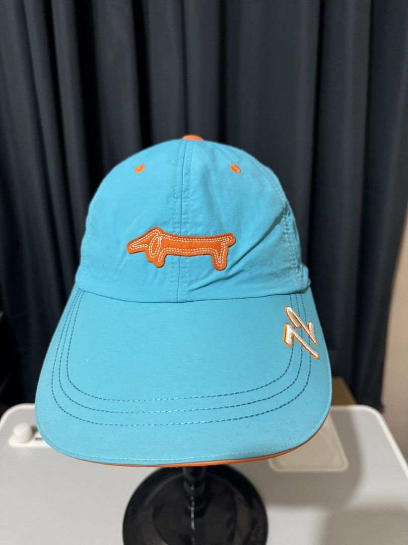 Louis Castel Blue Dachshund Golf Cap (Category: Hats & Beanies) located in Iligan City. Submitted by kitkatdeclutters (Listing ID 1456379717, Image 2). Description: - Cool blue Louis Castel cap - Features a cute orange dachshund logo on the front - Orange '72' detail on the brim - Orange trim - Adjustable strap at the back - Ideal for golf or casual wear.
