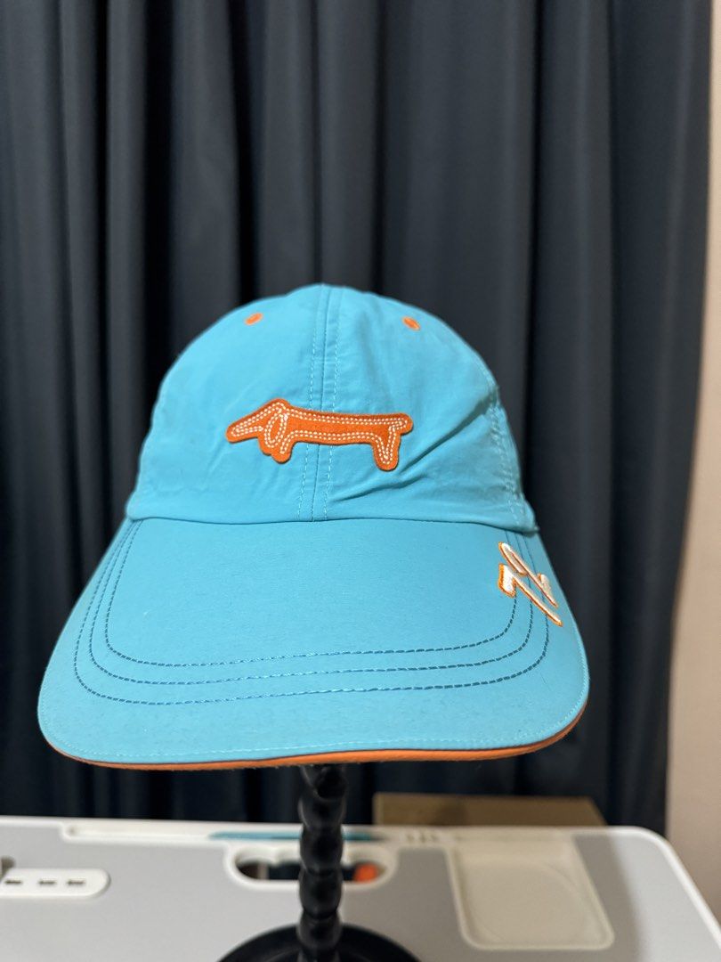 Louis Castel Blue Dachshund Golf Cap (Category: Hats & Beanies) located in Iligan City. Submitted by kitkatdeclutters (Listing ID 1456379717, Image 3). Description: - Cool blue Louis Castel cap - Features a cute orange dachshund logo on the front - Orange '72' detail on the brim - Orange trim - Adjustable strap at the back - Ideal for golf or casual wear.