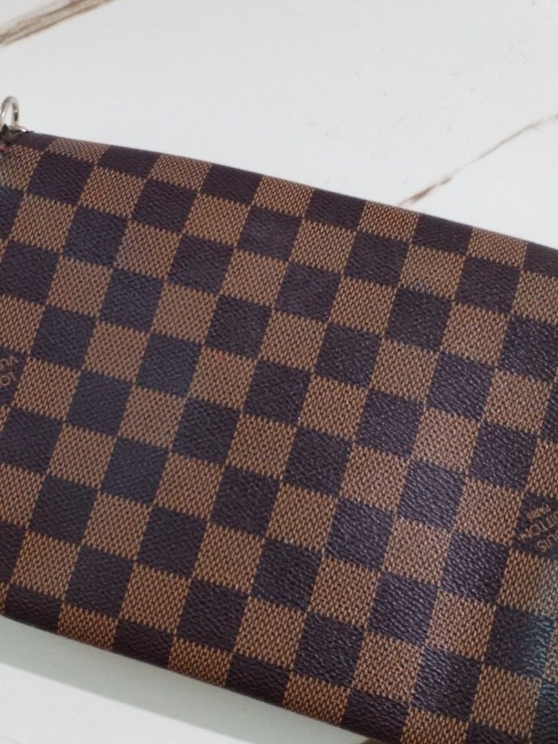 Louis Vuitton Damier Ebene Canvas Shoulder Bag (Category: Luxury Bags & Wallets) located in Quezon City. Submitted by hesperiana (Listing ID 1456315997, Image 2). Description: UKAY (not sure if legit or not) - Classic Louis Vuitton shoulder bag in Damier Ebene canvas. - Iconic checkered pattern. - Elegant gold chain strap. - Secure metal clasp closure with Louis Vuitton Paris engraving. - Luxurious red interior lining. - Versatile for everyday us